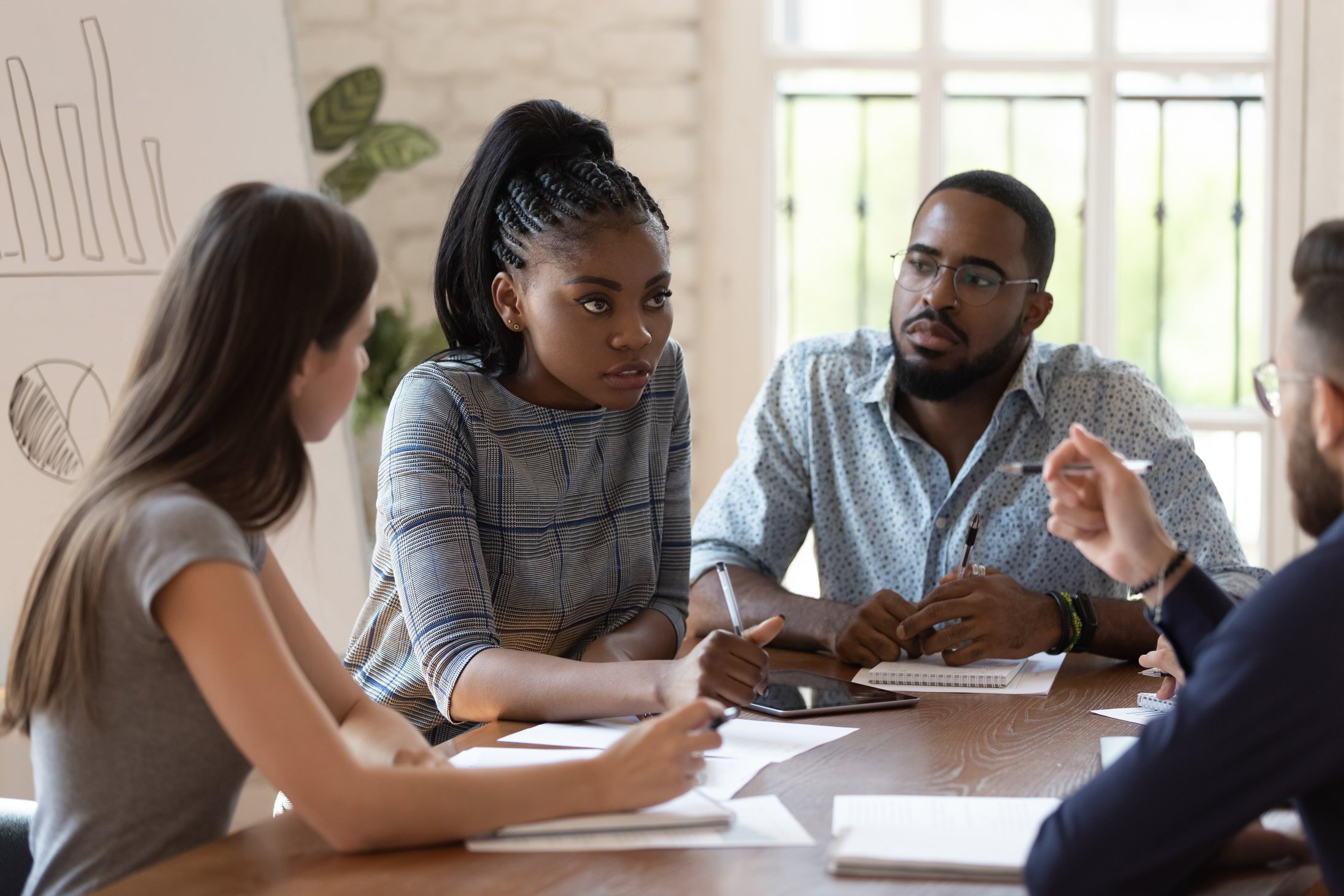 Focused female black executive teaching training workers at office briefing